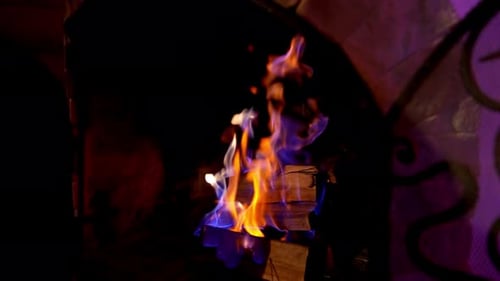 Blaue und orange Flamme im modernen Kamin. Holzscheite brennen im gemauerten Kamin.