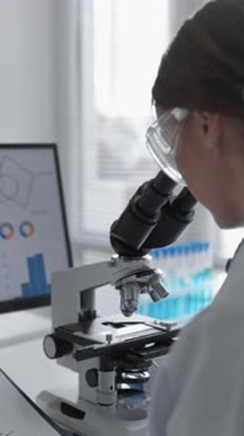 Researcher Using Microscope in Bright Laboratory