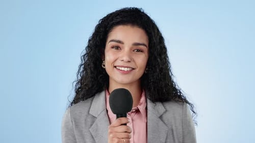 Face, microphone and news with a woman reporter on a blue background in studio for an interview