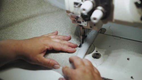 Frauenhände näht Stoff mit einer Nähmaschine