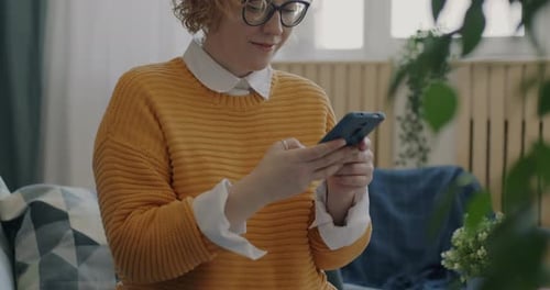 Woman Uses Smartphone Indoors While Smiling
