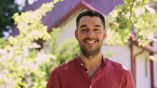 Smiling Young Man Posing Outdoors Near House