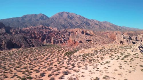 Aerial view drone flying over scenic red rocky mountains and arid desert