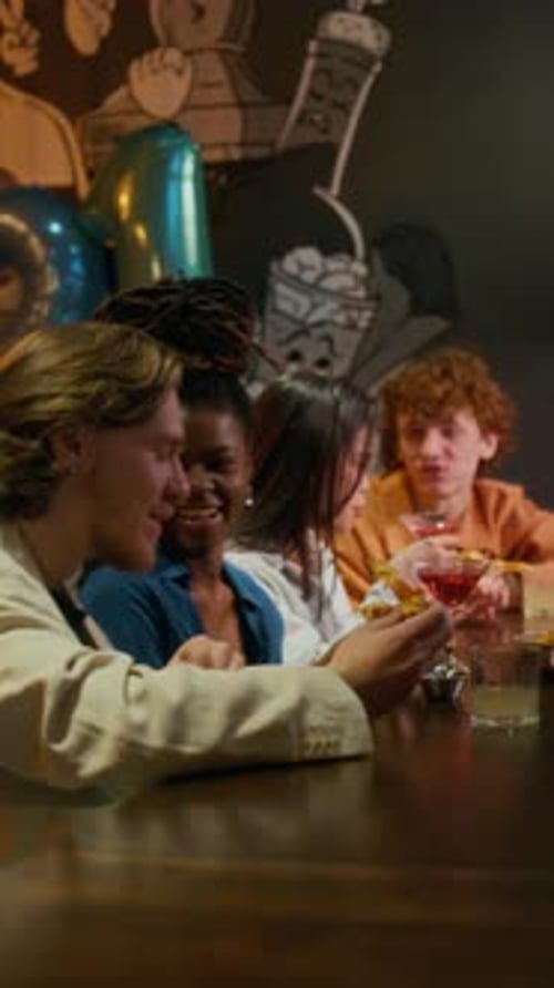 Group of Friends Chatting and Enjoying Drinks, Celebrating Birthday in Bar
