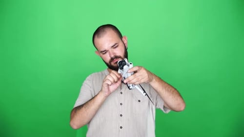 young man preparing his drone for flight in front of green screen