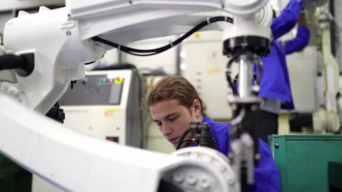 Engenheiros inspecionando e verificando a máquina automatizada de robôs de soldagem de máquinas de armas na fábrica.