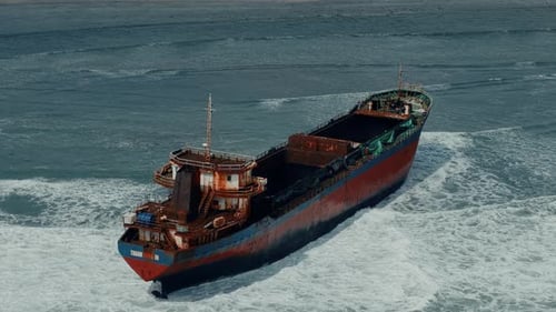 Luftaufnahme, Blick von oben auf das alte rostige gestrandete Logistikschiff am Strand