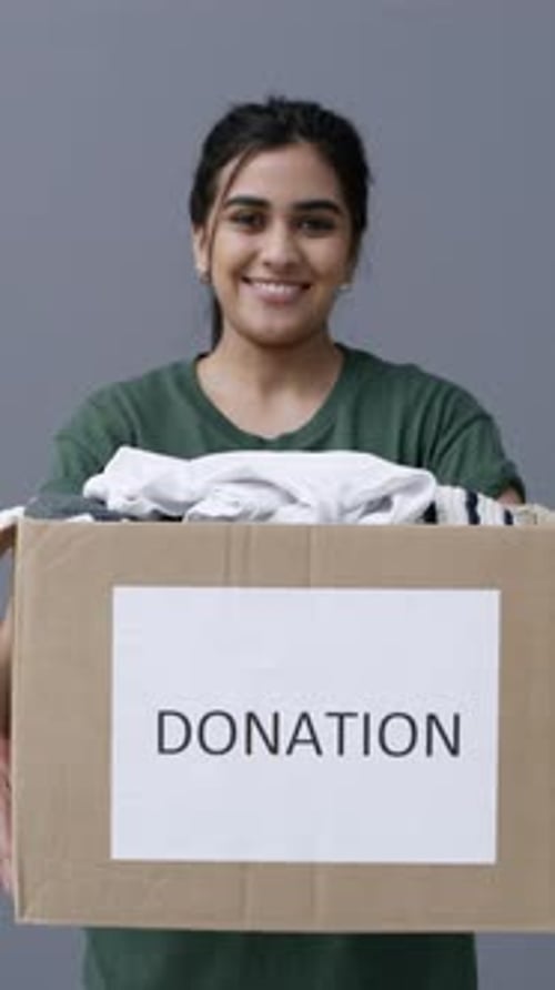 Face, woman or clothes in donation box for non profit, community care or volunteer in studio