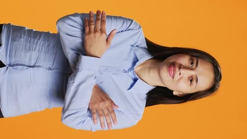 Vertical Video Happy Woman Poses with Arms Crossed in Studio