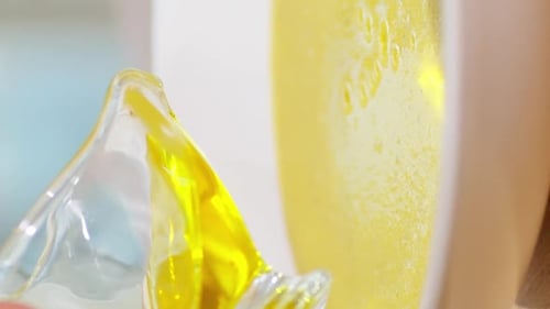 Vertikales Video: Die Hand einer Frau gießt Olivenöl aus einer Glasschale in die Suppe