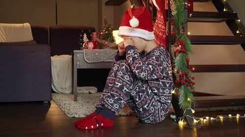 Little upset boy got sad and started crying while waiting for Santa on Christmas eve