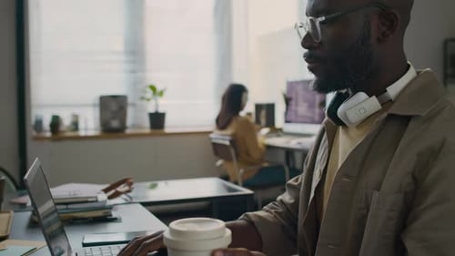 Male Web Developer Drinking Coffee Creating Software Program in Office