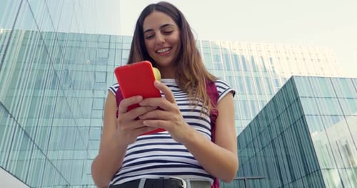 Young Woman Uses Mobile Phone in Urban Setting
