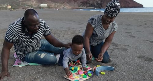 African Family Playing With Wood Toys On The Beach - Black Kid Having Fun With Mother And Father ...