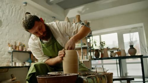 Ein Mann stellt einen Tontopf auf einer Keramikscheibe her. Keramik, Nahaufnahme: Ein Töpfer macht Töpferhandwerk, Ton