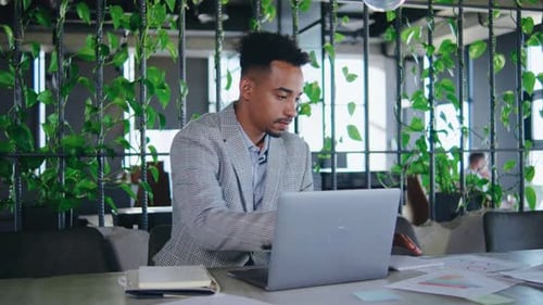 Ein junger Berufstätiger zeichnet sich durch ein abgelegenes Büro inmitten üppiger Grünanlagen aus und bringt Beruf und Privatleben in Einklang
