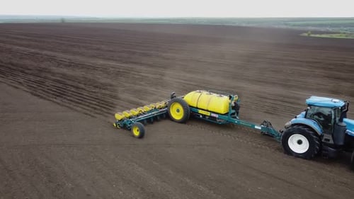 Blue tractor OA working on the field in Ukraine