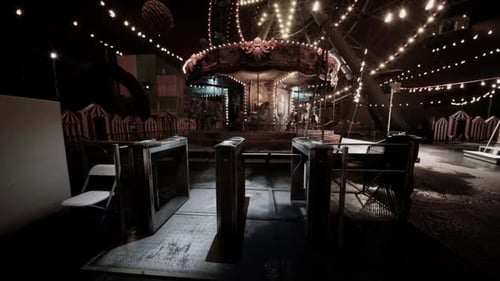 Deserted Amusement Park at Night with Illuminated Carousel and Attractions