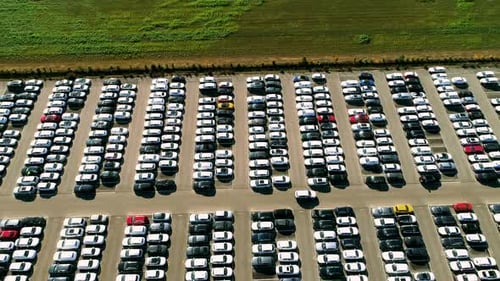 Aerial footage of finished cars ready to be shipped on huge distribution center