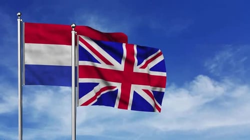 Netherlands and United Kingdom Flags Waving Against Blue Sky