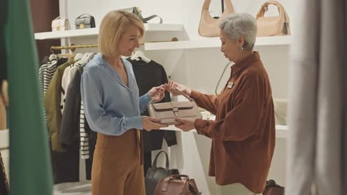 Blonde Woman Choosing Bag in Designer Boutique
