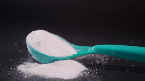 Close Up of Baby Milk Powder and Spoon on Black Background