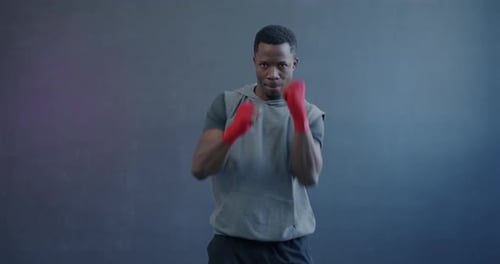 Man with Red Wraps Practicing Boxing Punches