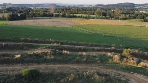 Aerial shot of motocross rider on a yellow dirt bike riding fast on a long straight on a winding dir