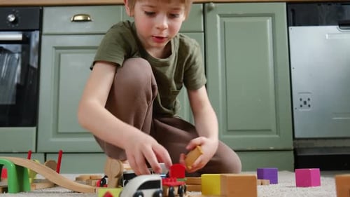 Boy Plays with Wooden Toy Train at Home