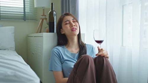 Sad Woman Drinking Wine in Bedroom