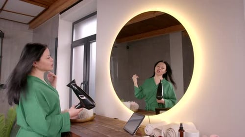 Woman Dries Hair in Bright Bathroom with Hairdryer