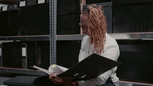 Woman reviewing documents in a dark storage room