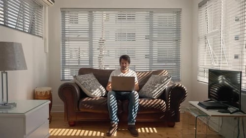Man Works on Laptop at Home During Day