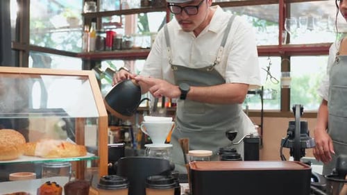 Close up of professional barista or waiter working in coffeehouse shop.