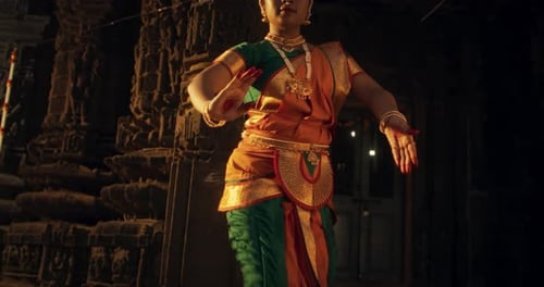 Portrait d'une Indienne présentant gracieusement les mouvements des jambes de la danse Bharatanatyam, habillée