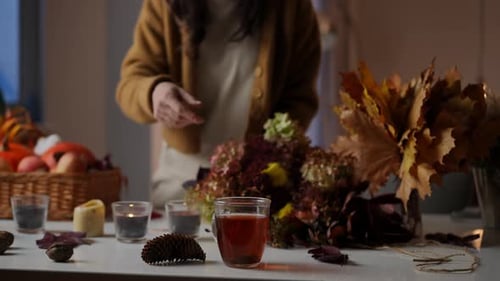 Woman Creating Floral Arrangement with Hot Tea
