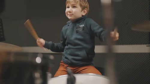 Little Boy Playing Drums in Music Studio