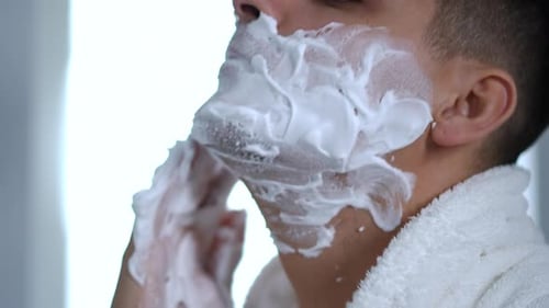Young Adult Man Applying Shaving Cream to Face