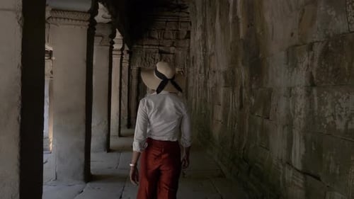 Beautiful woman walking through ancient ruins of old stone temple in Cambodia