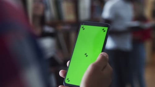 Man is Holding a Modern Smartphone Gadget with a Green Screen