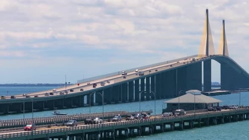 Aerial View of Fishing Pier at Sunshine Skyway Bridge Over Tampa Bay in Florida with Moving Traffic