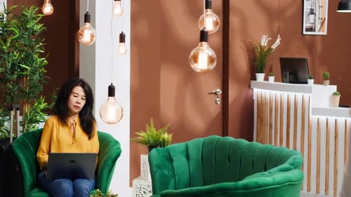 Woman Working on Laptop in Hotel Lobby