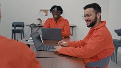Cheerful Diverse Male Convicts Laughing during Coding Lesson in Prison