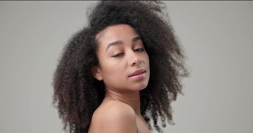 Woman with Curly Hair Posing in Studio