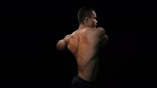 Muscular Man Warming Up on Black Background