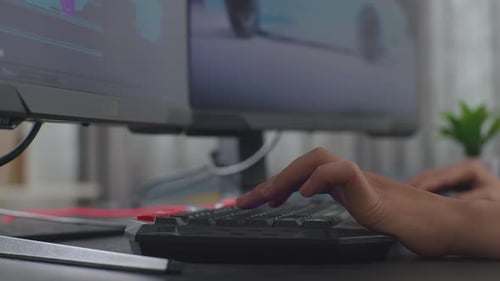 Nahaufnahme von Frauenhänden, die die Computertastatur berühren, während sie an einem 3D-Modell eines Elektrofahrzeugs arbeiten