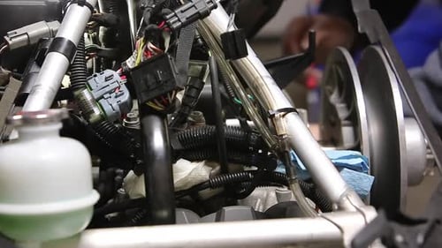 Mechaniker arbeitet am Schneemobilmotor im Hintergrund des Fahrgestells