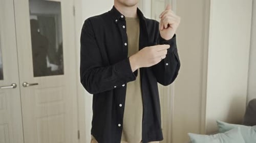 Man Rolling Sleeves and Buttoning Up Shirt Inside
