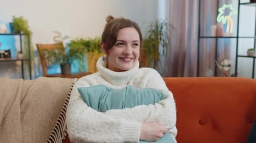 Smiling Woman Hugging a Pillow on Sofa