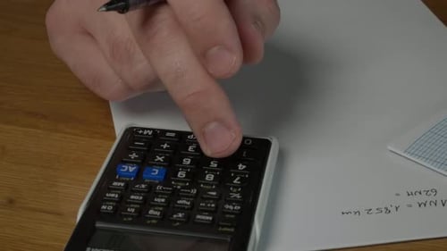 Close Up of Calculator and Writing on Paper